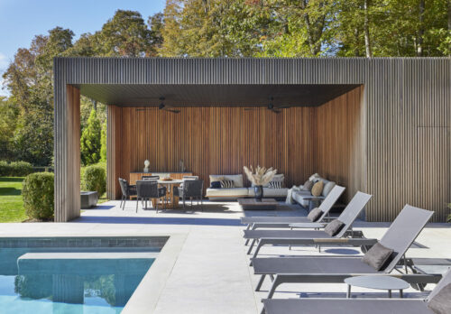 Outdoor lounge area with in-ground pool, lounge chairs, and covered outdoor patio