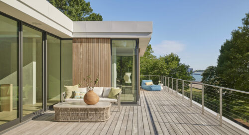 Outdoor living space next to Lake Michigan, featuring outdoor lounge chair and outdoor sofa