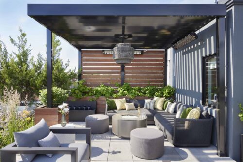 Outdoor living space with sectional, greenery, and side tables