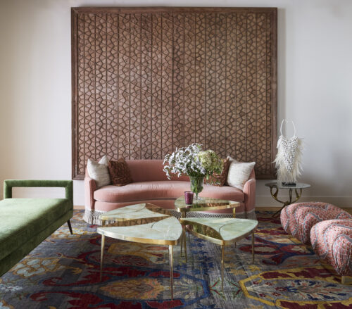 Interior design studio featuring vintage wall art, a pink couch, and other furnishings