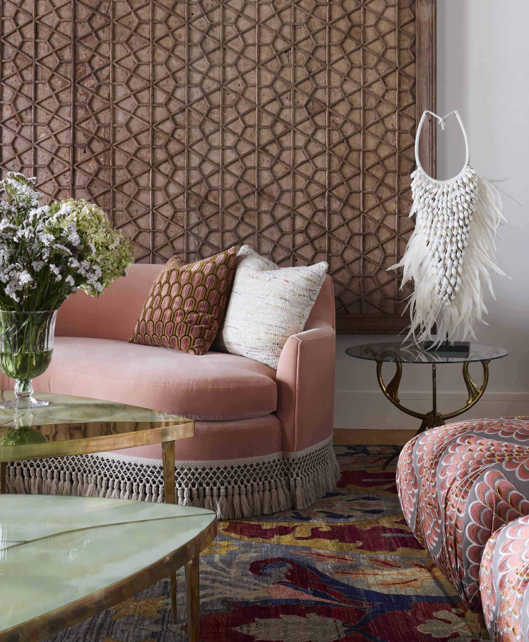 Interior design studio featuring pink couch, throw pillows, patterned rug, and accessories