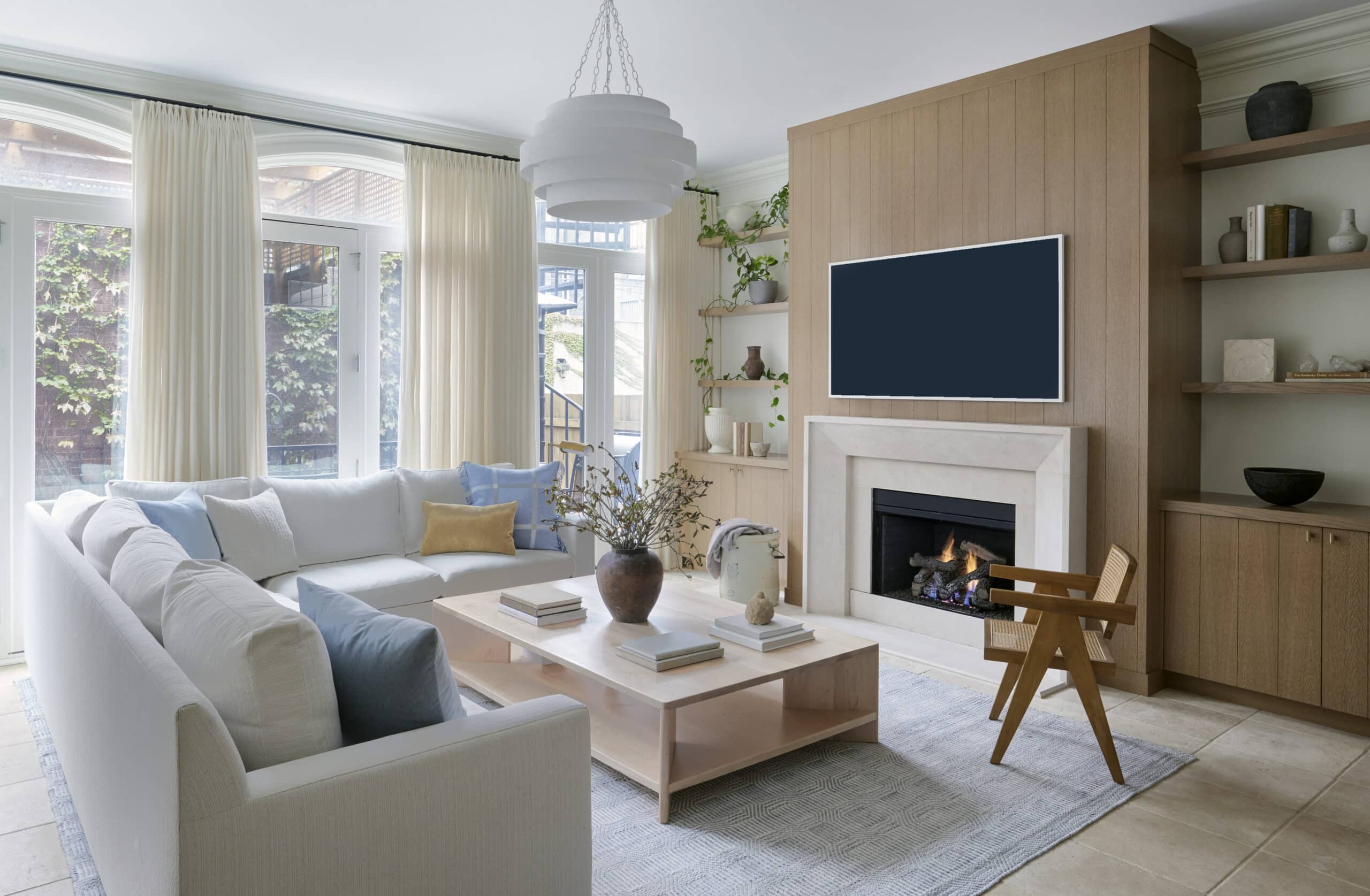 Living room with white couch, light wood, and built-in bookshelves