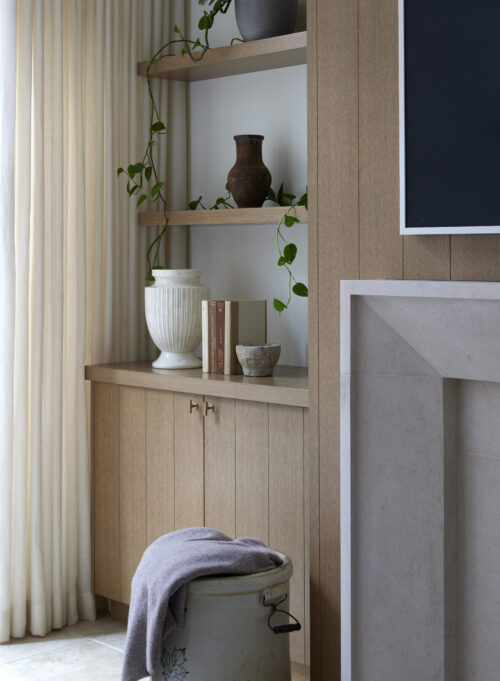 Custom built-in bookshelves featuring white vase, books, and greenery.