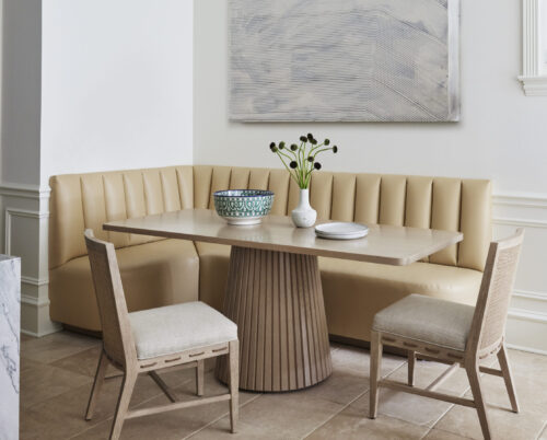 Kitchen table featuring custom banquette, dining chairs, flowers, and art.